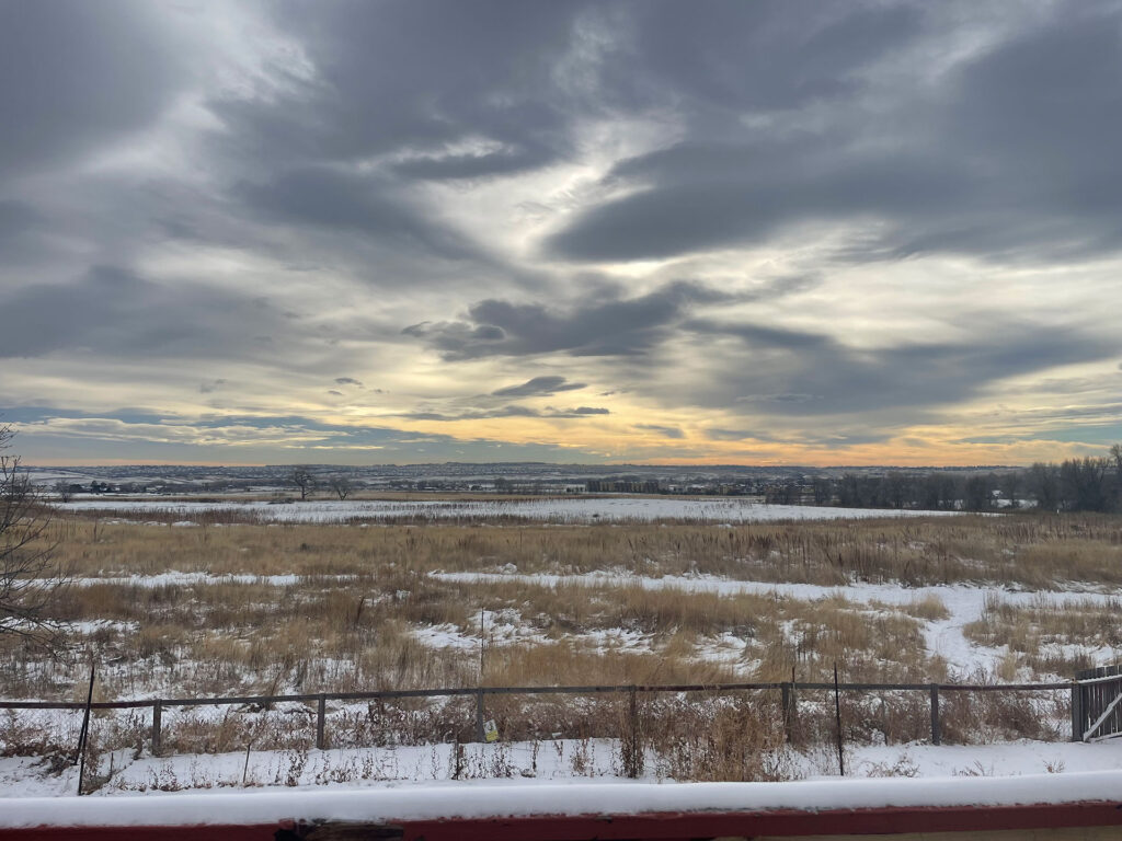 Snow covered field during sunrise